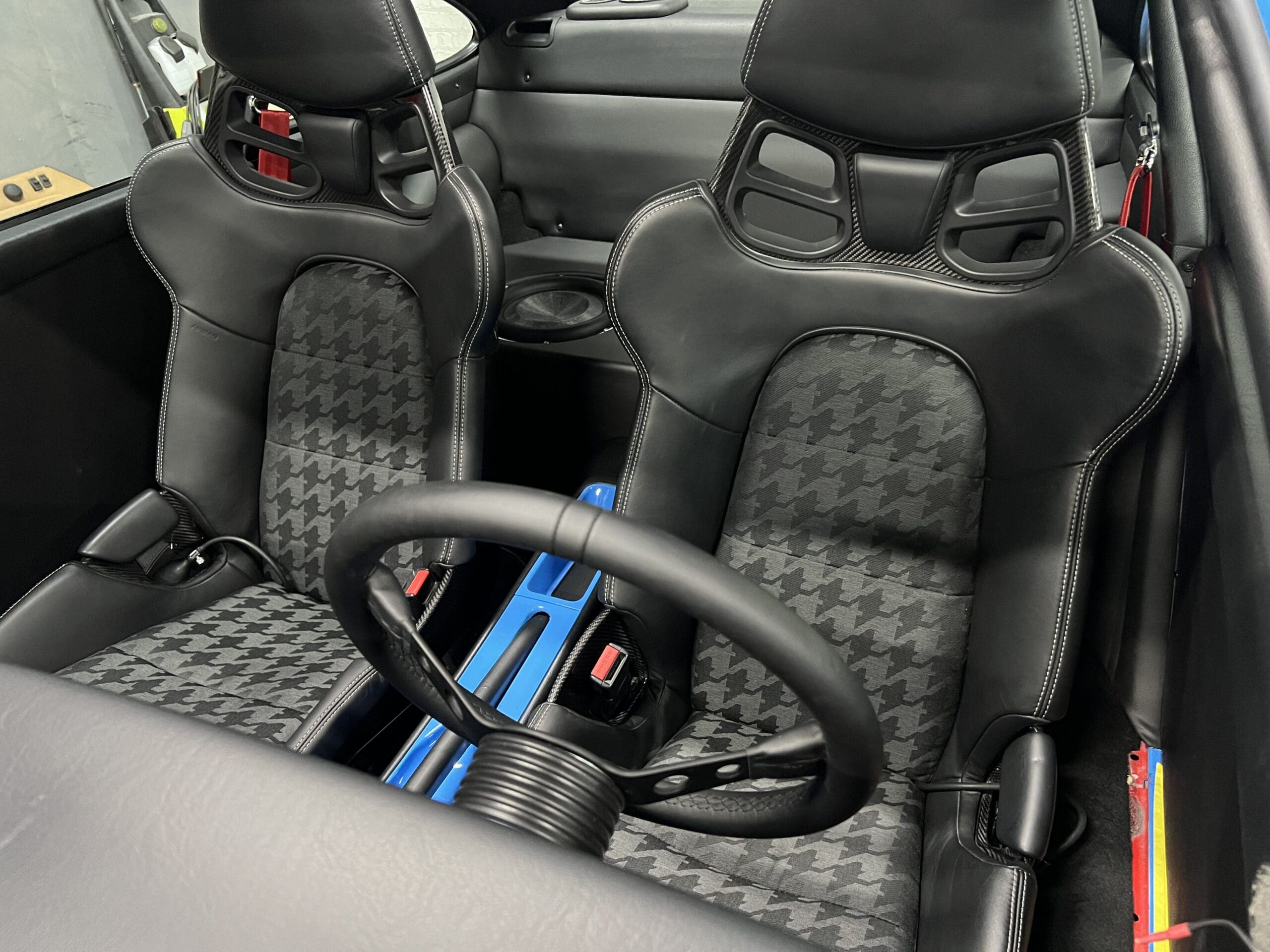 Inside a two-seat sports car, showcasing a stylish dashboard and plush seating for an exhilarating driving experience.