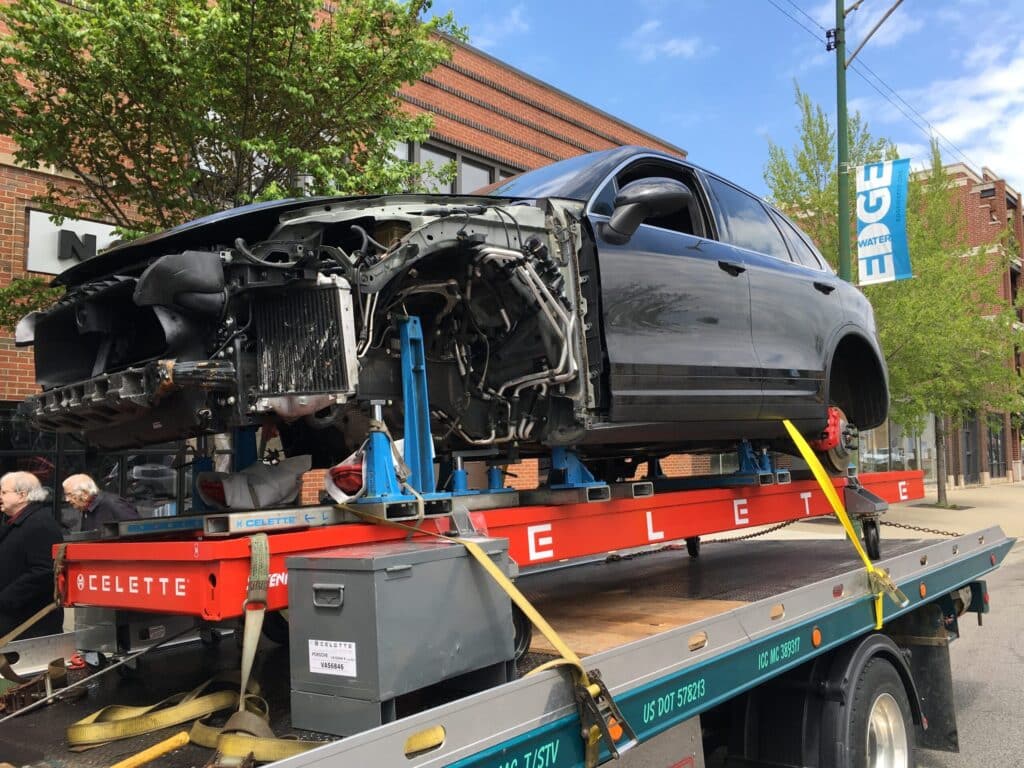 A car being transported on a flatbed truck, secured and ready for delivery.