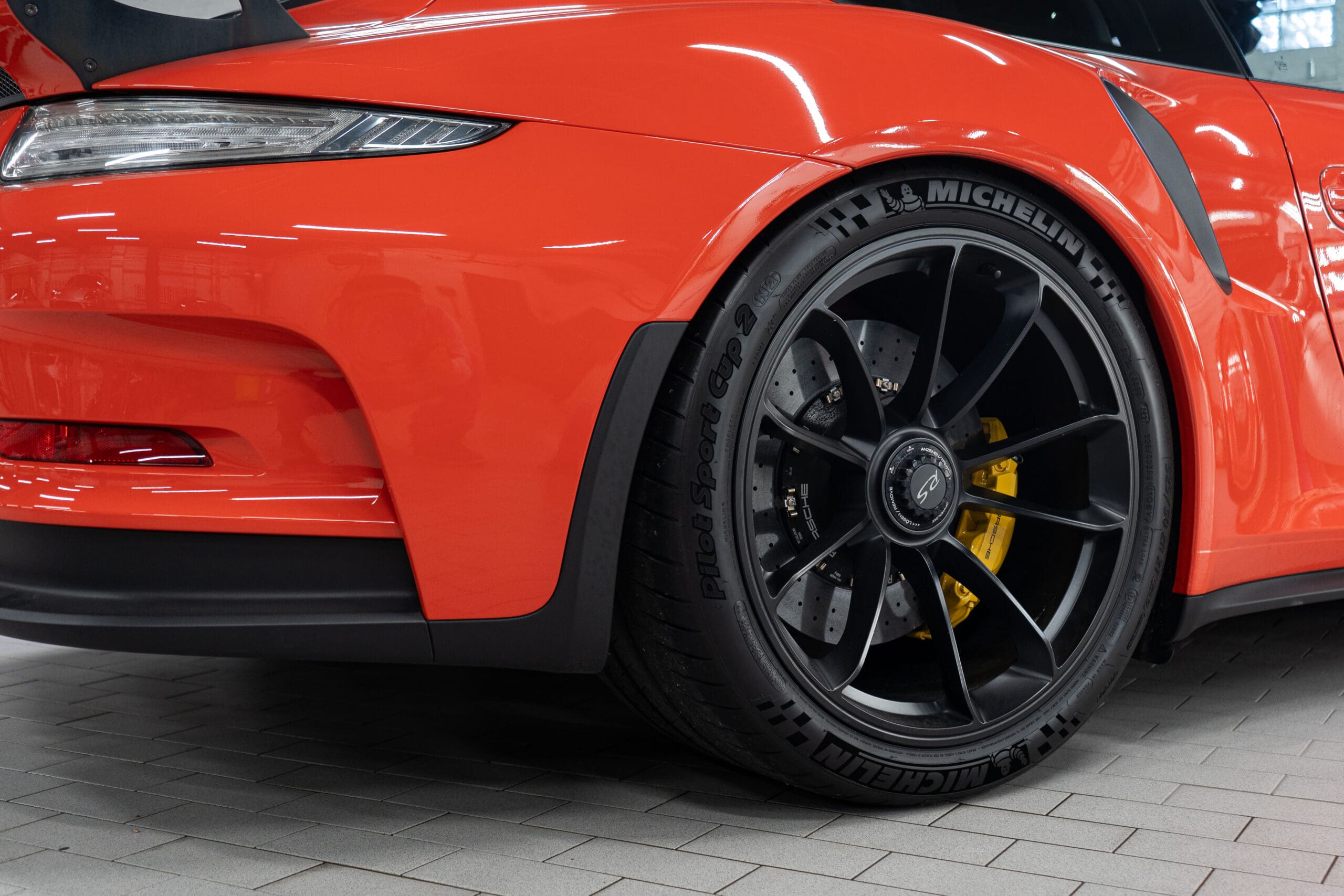 Close up of the Michelin tires on a newer, electric orange super car