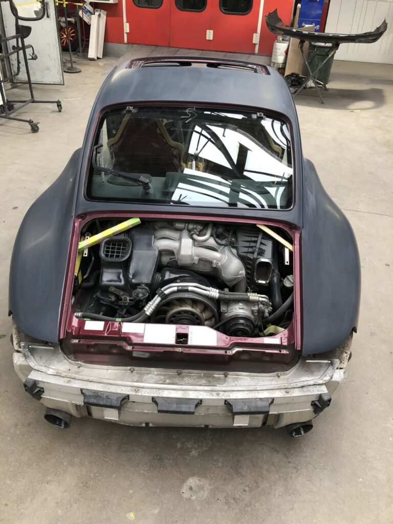 Open car hood revealing the engine bay, showcasing various components and wiring inside the vehicle.