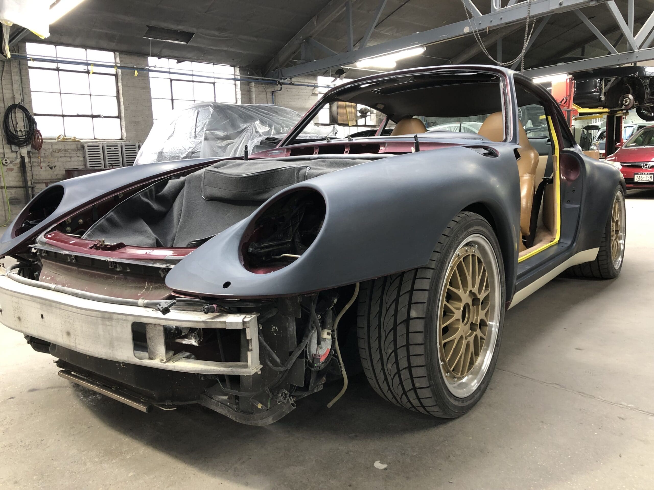 A Porsche 911 Carrera with a missing front end, showcasing its sleek design and damaged structure.
