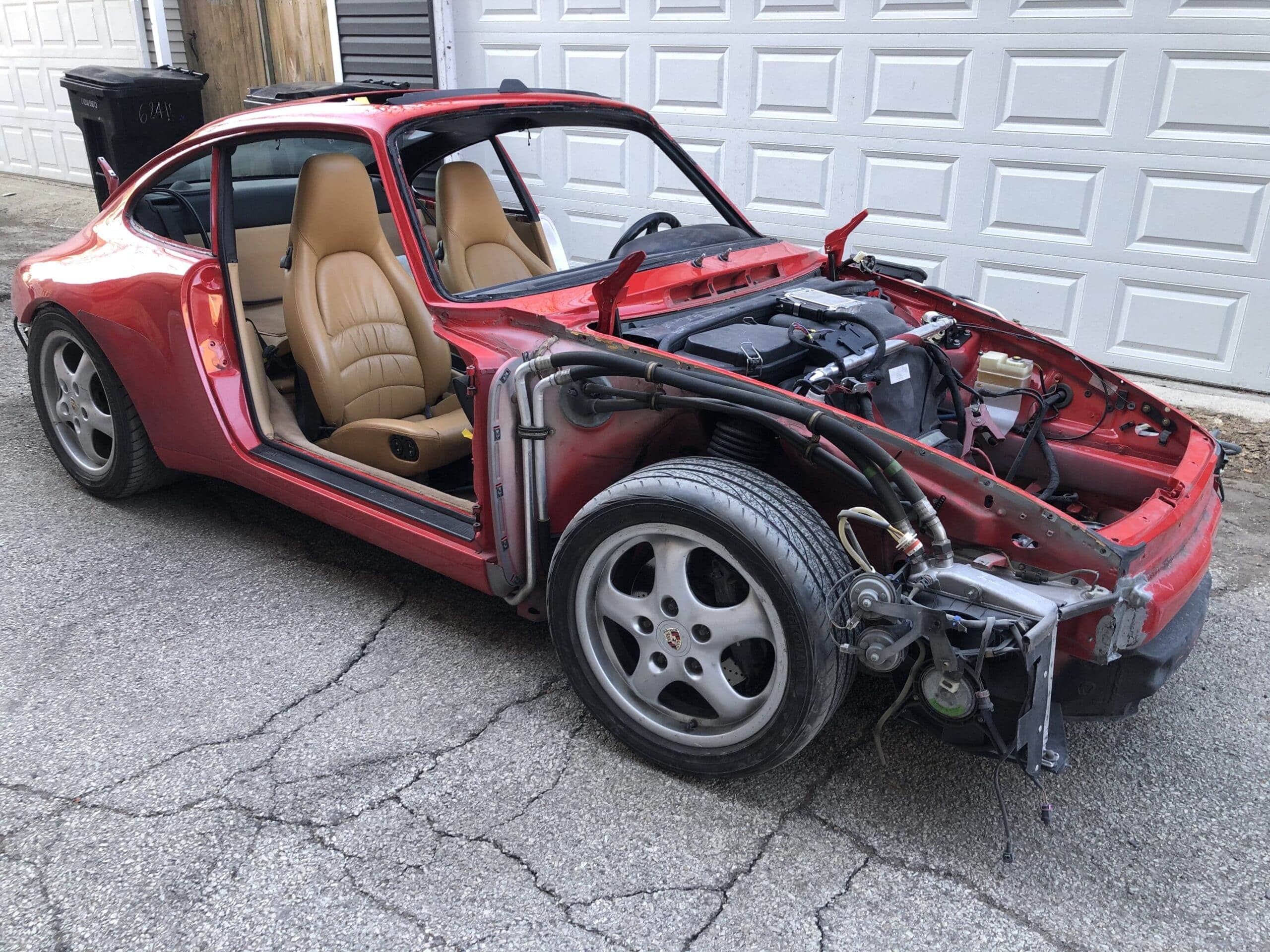 A red sports car with its hood open, revealing the engine and internal components.