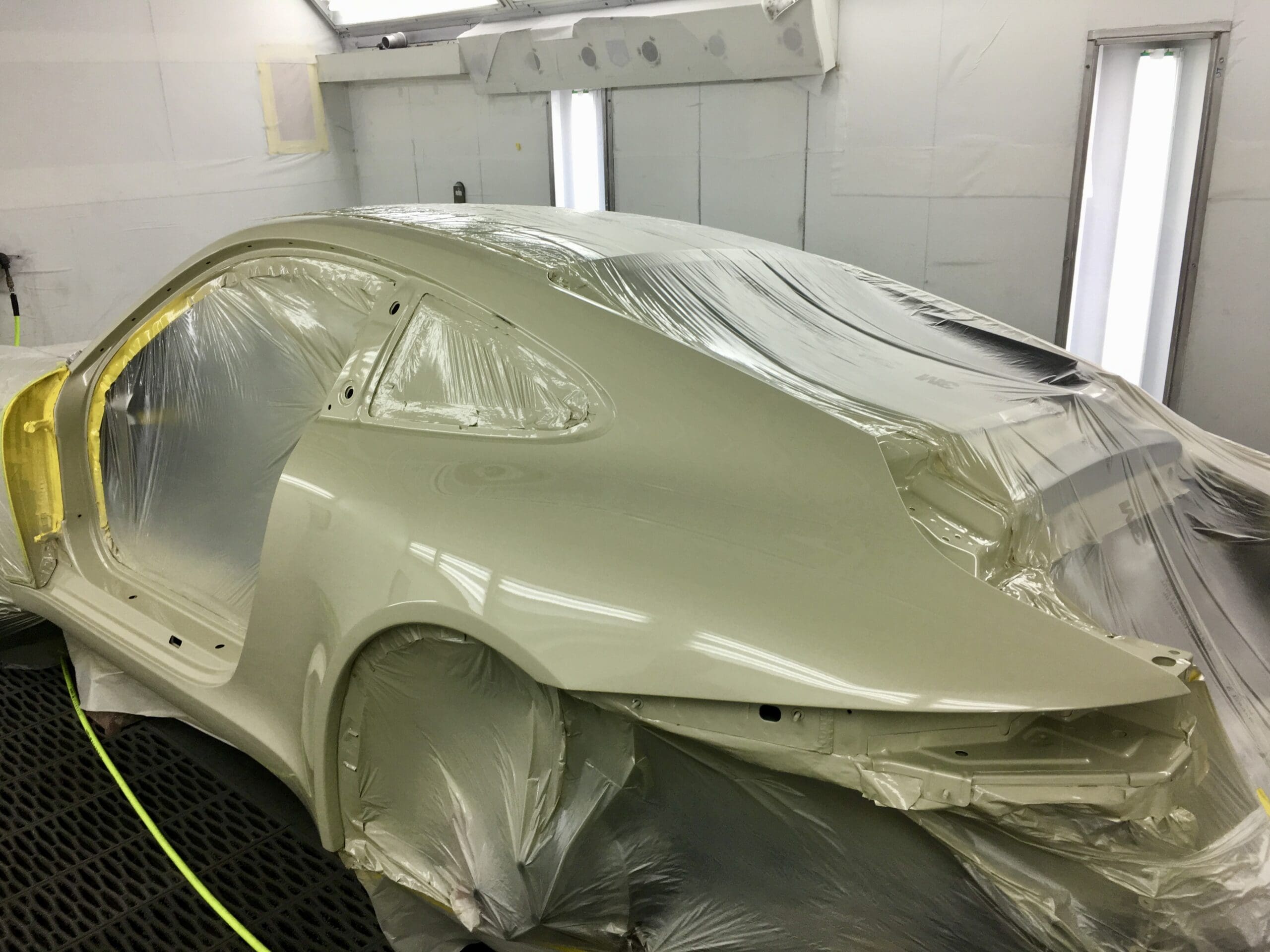 A car wrapped in plastic after it has been painted in an autobody shop